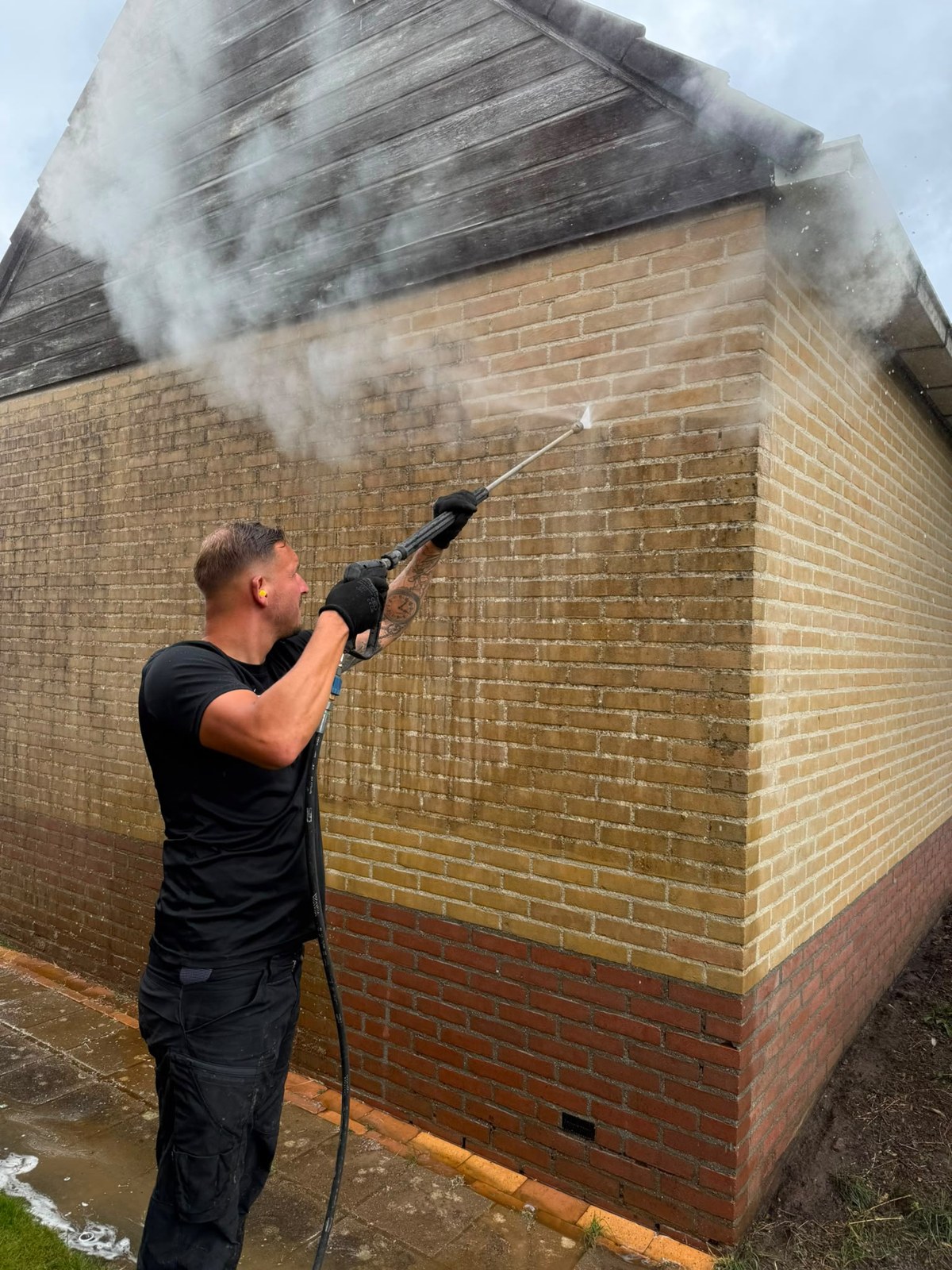 Kevin Hilbrink aan het werk bij het reinigen van een gevel